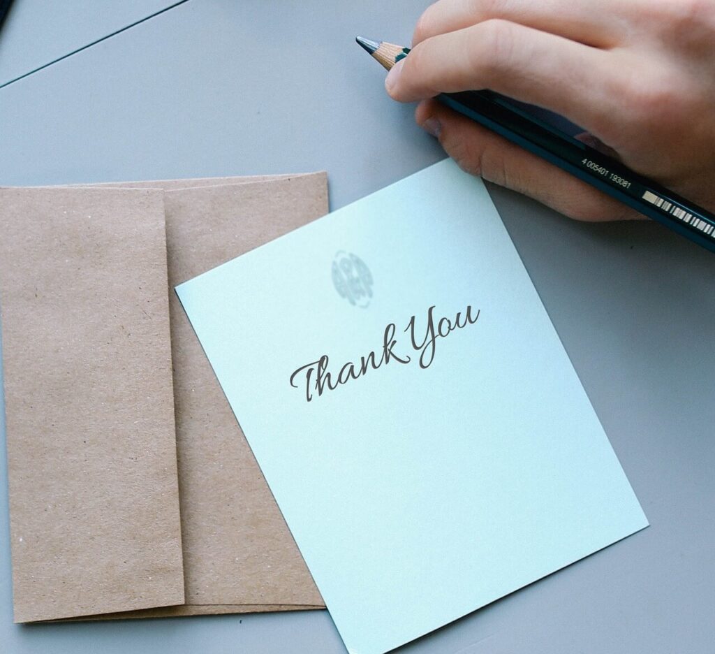 편지지에 연필로 Thank you 라고 글자를 적는다