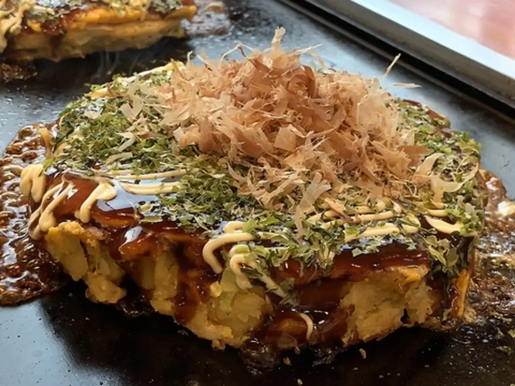 철판에 요리되고 있는 오코노미야키 요리