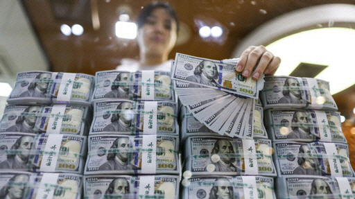 은행직원이 달러 뭉치를 세고 있는 모습